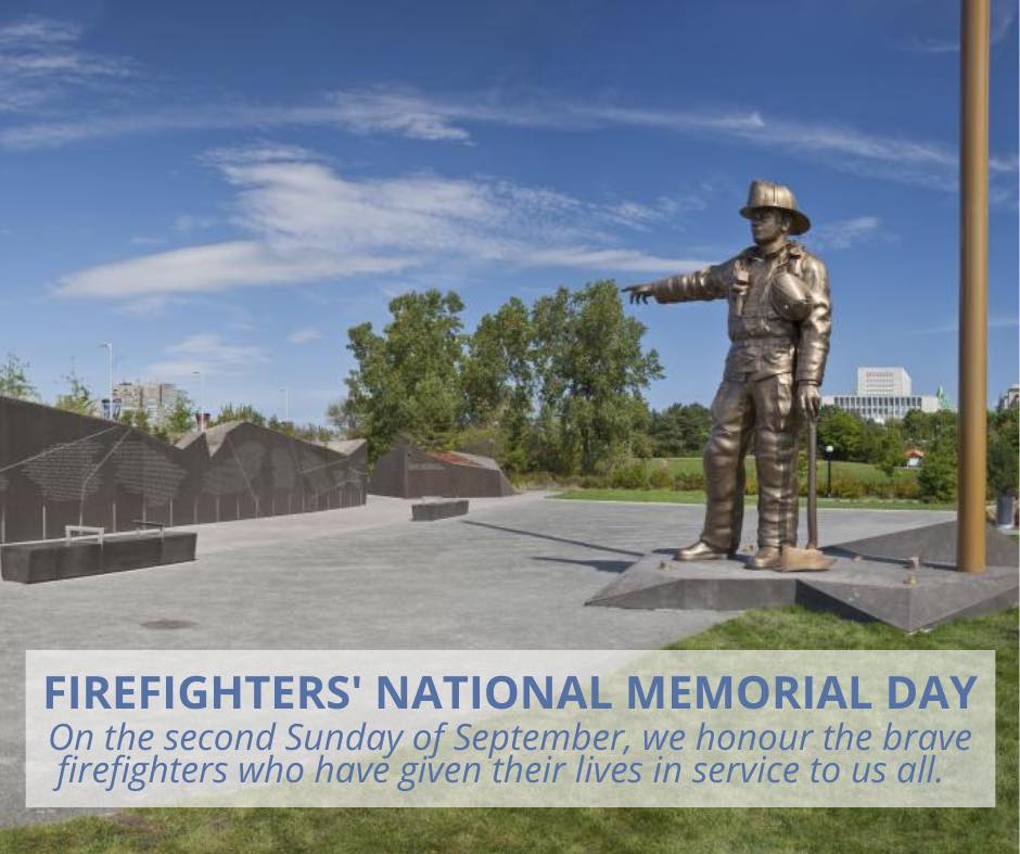 A bronze statue of a firefighter stands at a memorial