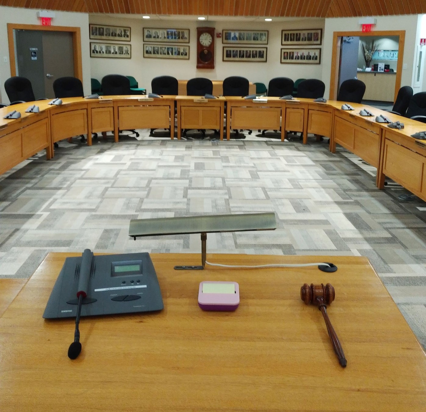Photo shows council chambers with wooden tables arranged in horseshoe