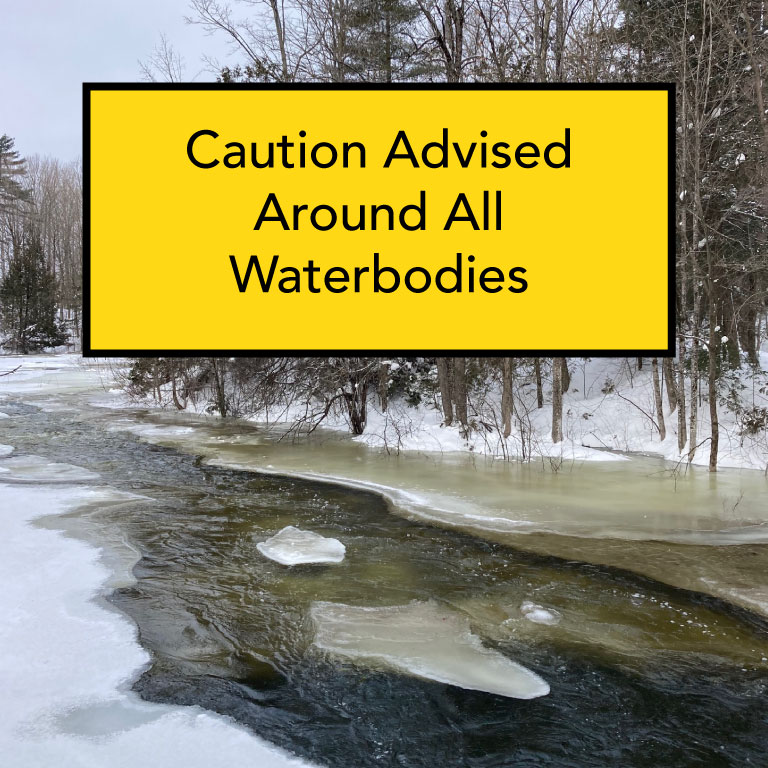 Photo of body of water with melting ice. A yellow box with black text reads 'Caution around waterbodies'