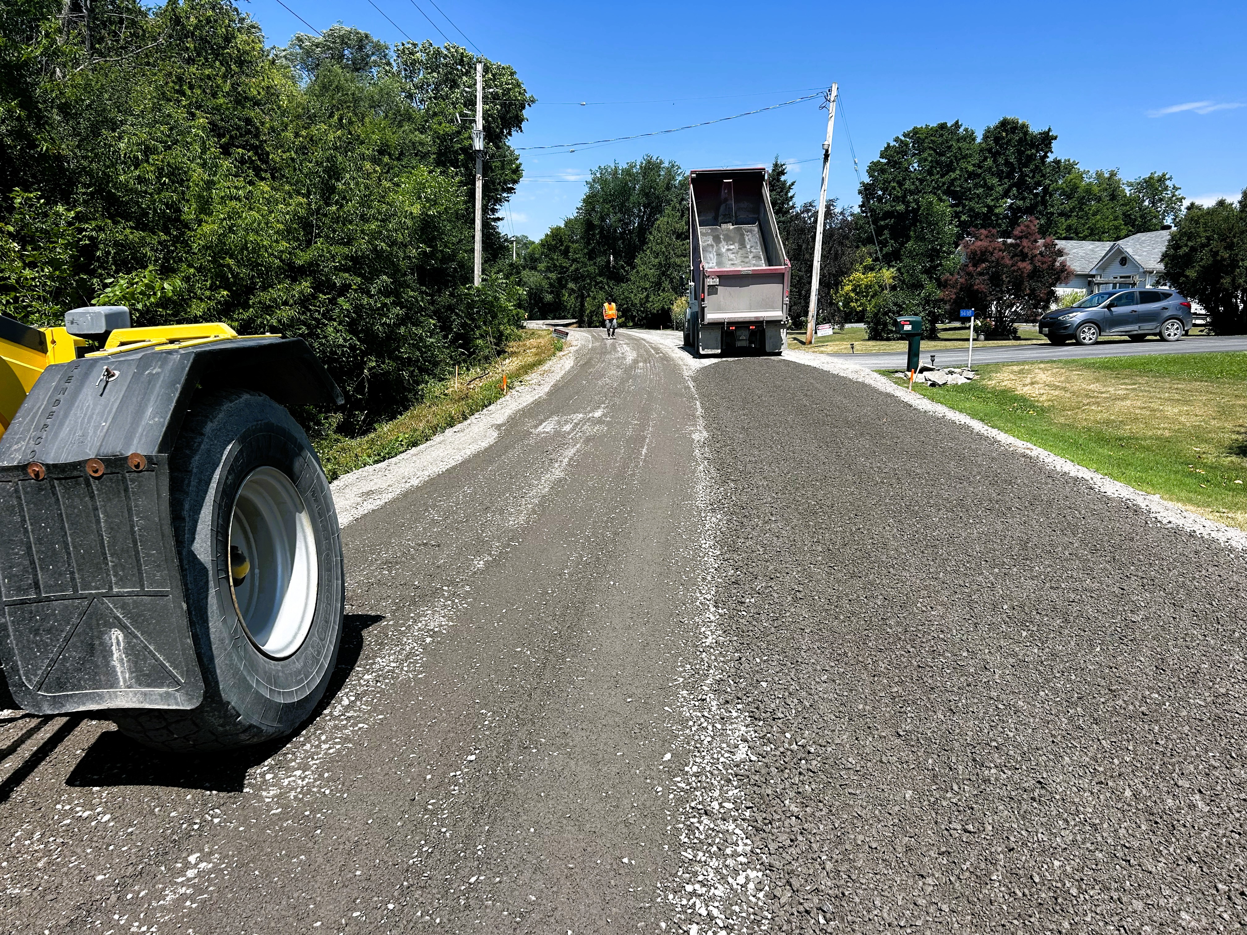 Photo of truck dumping gravel onto a road
