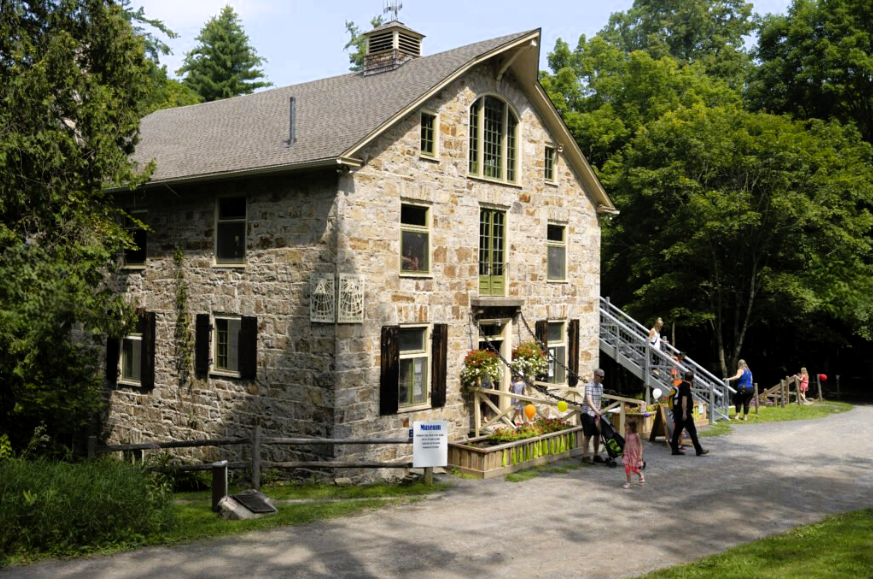 Photo of people walking outside in front of a stone mill