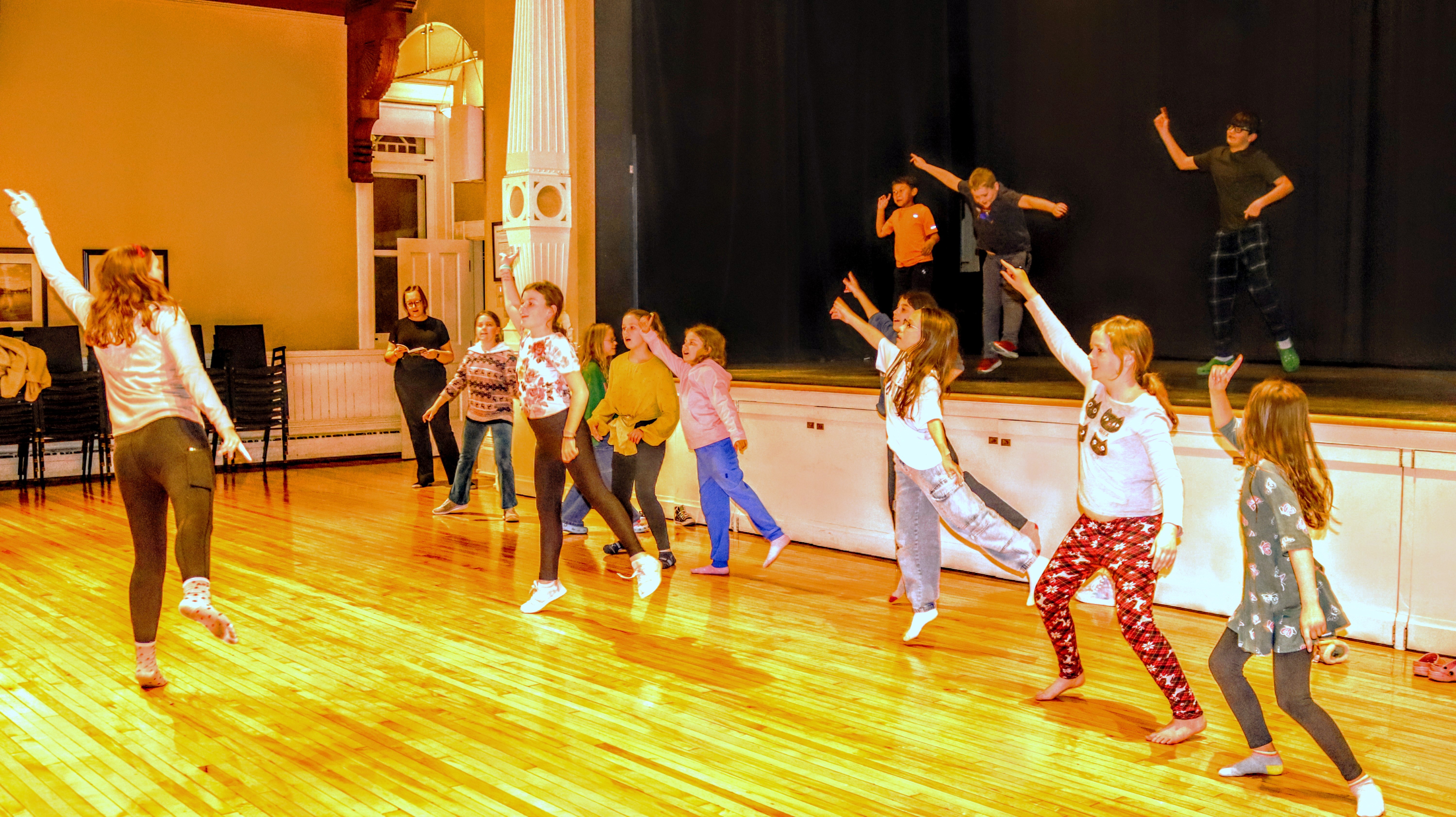 Children rehearse for a play in an auditorium