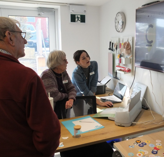 Three people look at a TV screen