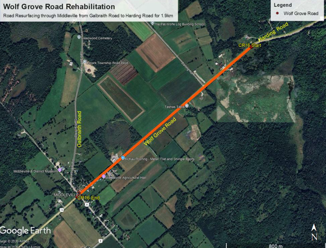 Satellite view of a forested area with a red line indicating a route. Text reads 'Wolf Grove Road Rehabilitation.'
