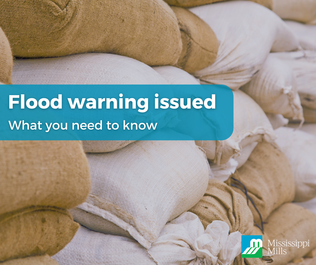 Piles of beige and white sandbags stacked on top of each other. A medium blue box with white text reads 'Flood warning issued - What you need to know.' The Municipality of Mississippi Mills logo is in the bottom right corner of the photo.