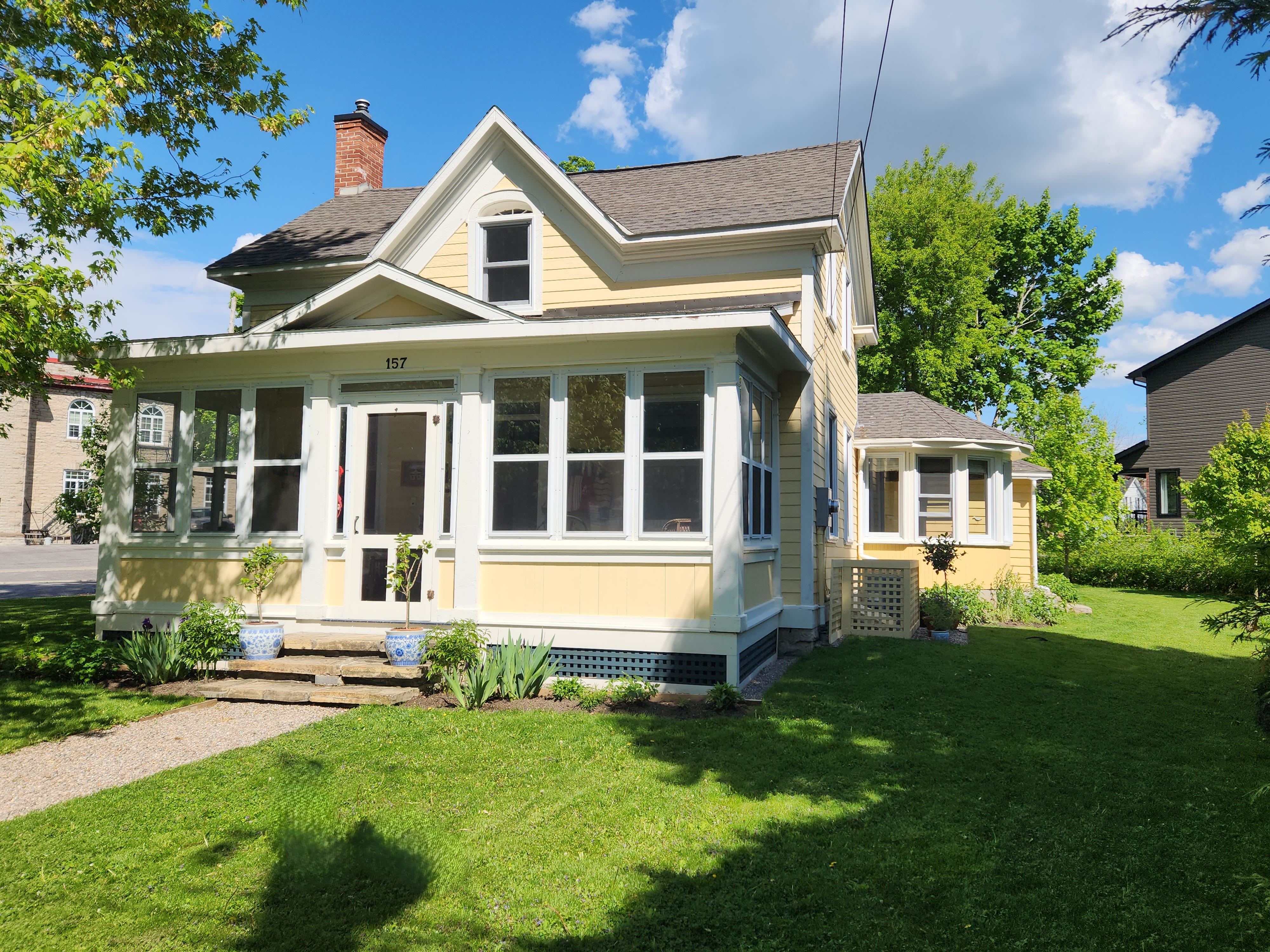 Photo of yellow and white home with green lawn