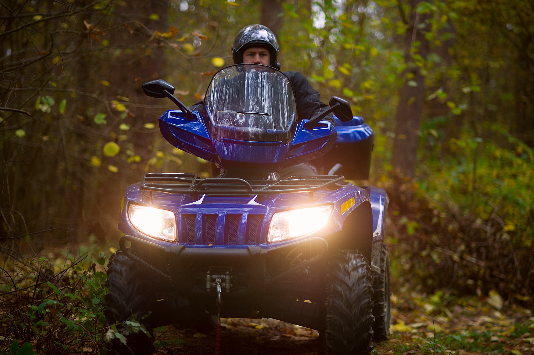 Photo of man riding ATV in forested area
