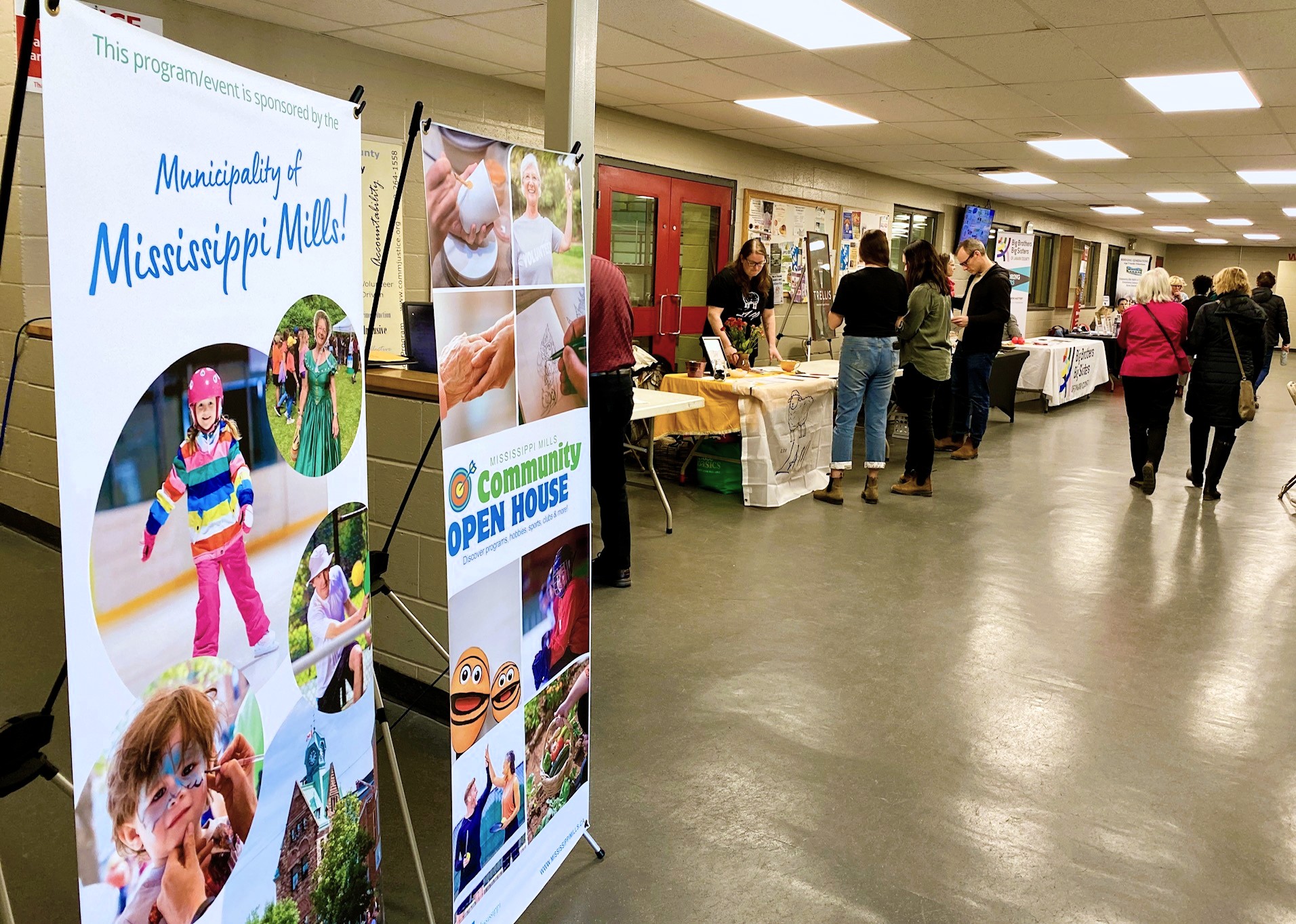 Tables are set up in an arena lobby for a Community Open House