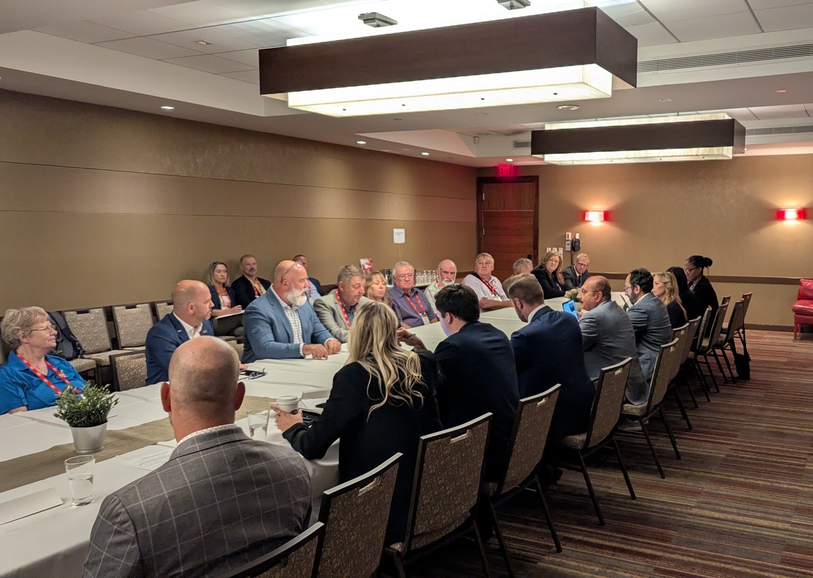 Group of people sit at a long table in a conference room