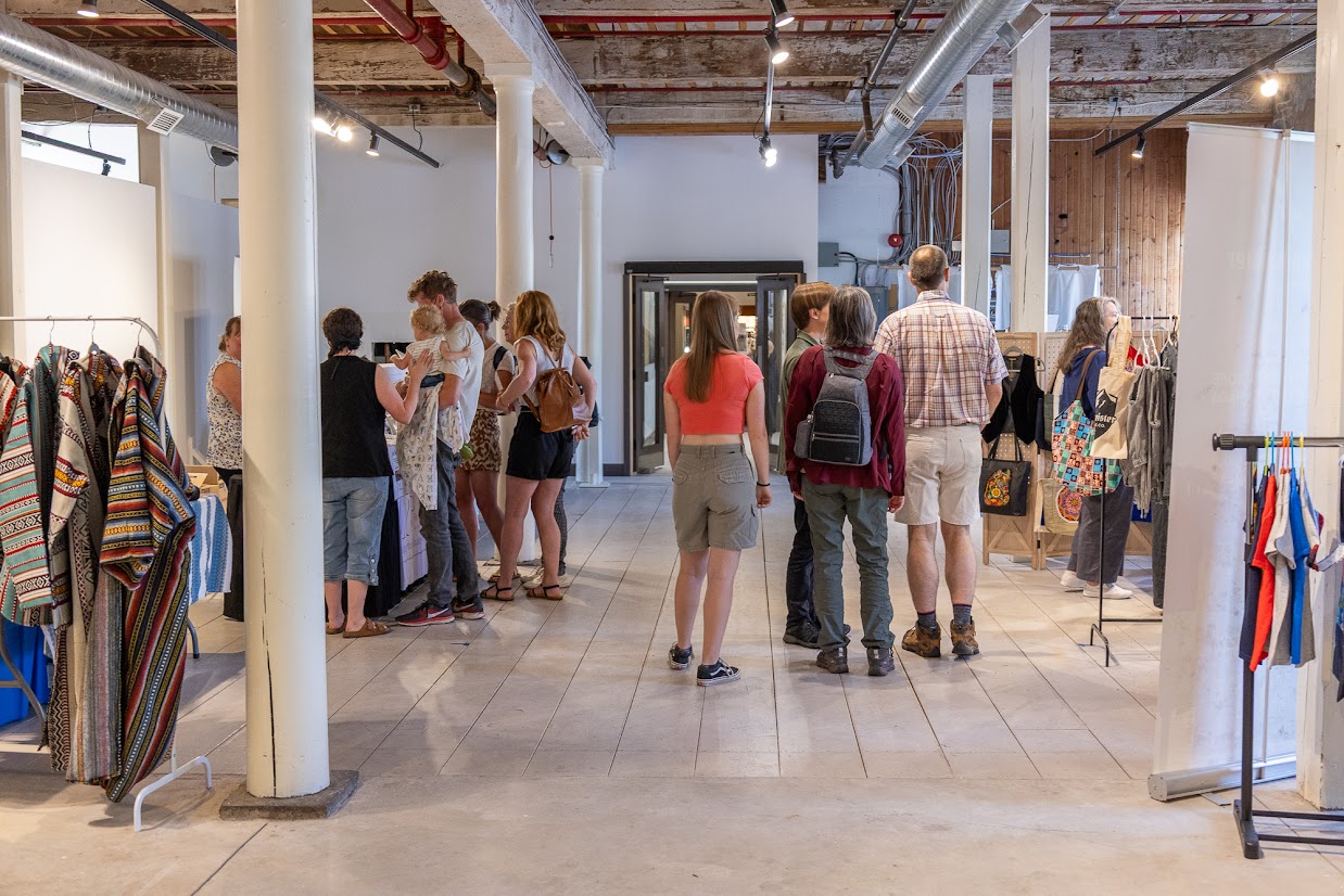 Photo of people walking through a museum looking at vendors