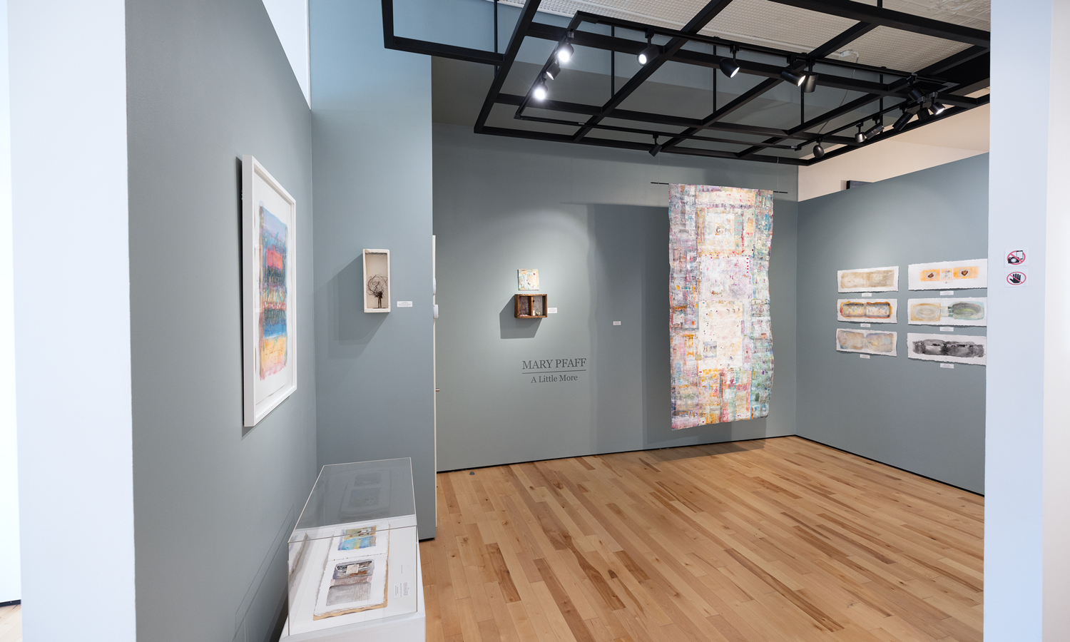Photo of artwork on grey walls in gallery space