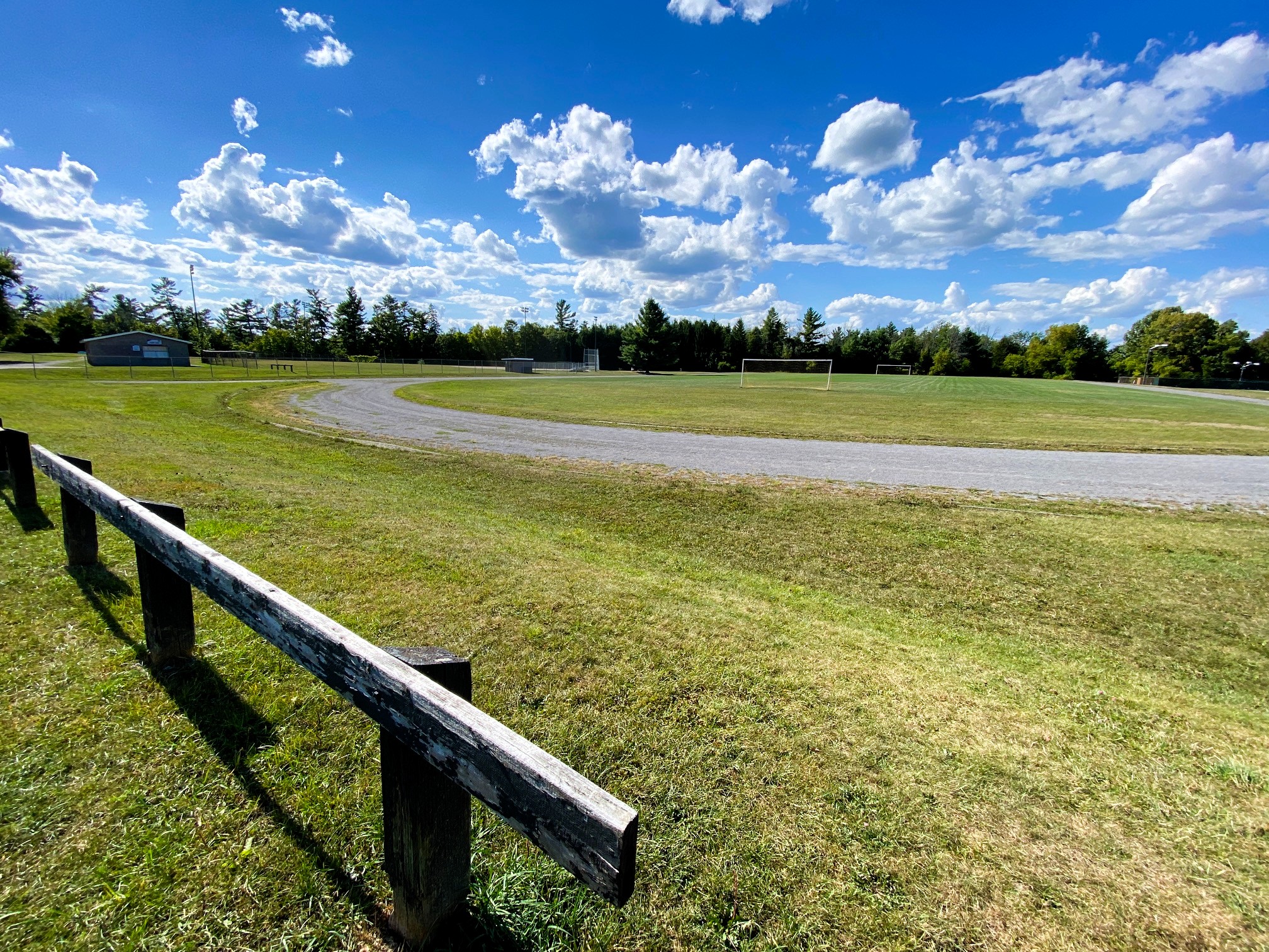 Photo of gravel track in a park with blue sky above